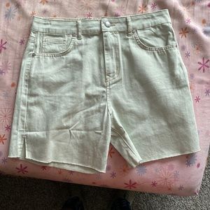 Light green mid length shorts.